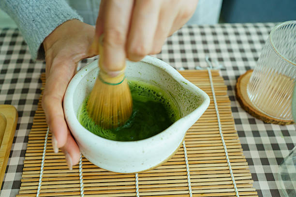 istock Whisking matcha tea creating rich frothy foam in natural light. 2240556664