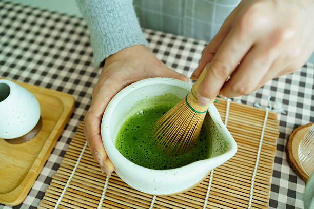 istock Whisking matcha tea creating rich frothy foam in natural light. 2240556667