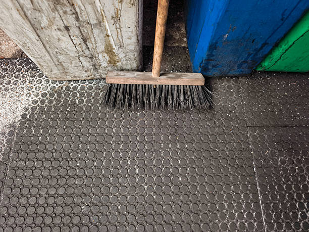 istock Cleaning salt from black rubber mat with wooden brush 2240562353