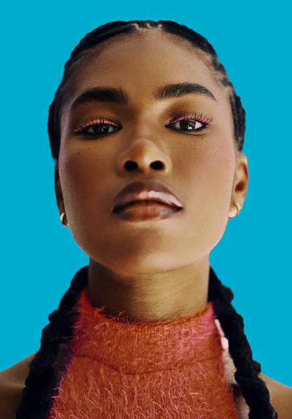 istock Confident Black Woman With Bold Makeup And Braids Against Blue Background 2240568809