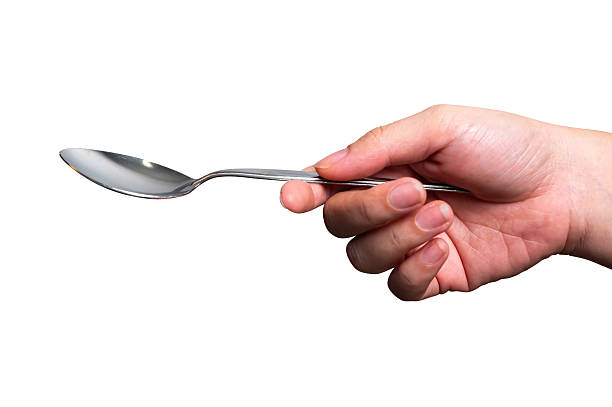istock Female hand holding a black plastic spoon isolated on white background. 2240569780