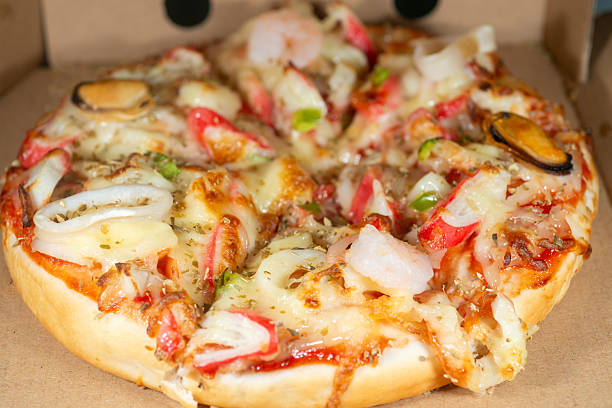 Macro image of cheesy seafood pizza, capturing the texture of melted cheese and crispy dough with fine depth of field.