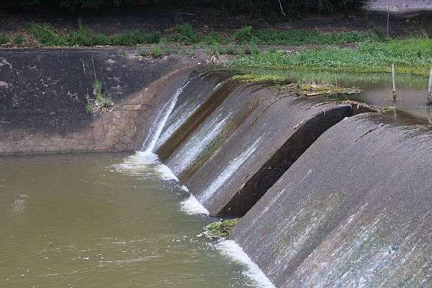 istock Flowing water over a concrete barrier, peaceful water feature in a natural setting, perfect for nature-themed projects. 2240574483