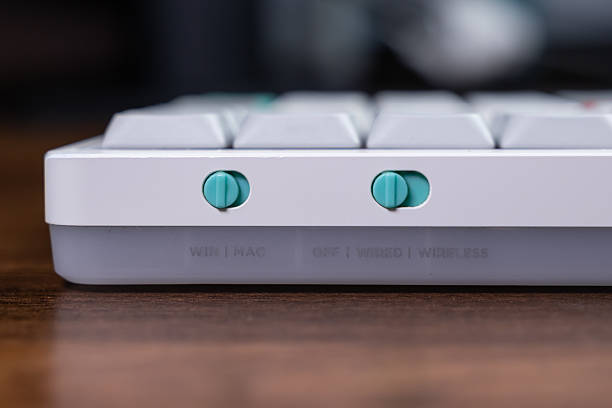 Stylish mechanical keyboard side with vibrant teal toggle switches managing WIN MAC operating system and WIRED WIRELESS connectivity for ultimate computer versatility