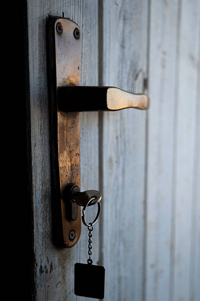 istock Rusty open door, handle with key in keyhole and keychain - Degraded city 2240576324