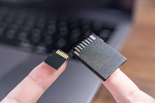 istock Fingers holding a compact micro SD card and a larger standard SD card, emphasizing modern digital memory storage for various electronic devices 2240576355