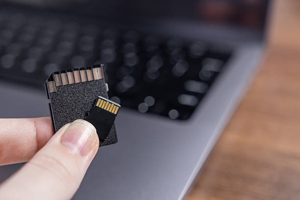 istock Fingers present two compact digital memory cards, a standard SD card and a smaller micro SD card, symbolizing portable data storage for modern electronics 2240576373