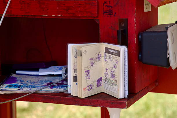 An open cyclist passport sits at the Hamdeok Seoubong certification station showing purple route stamps collected around Jeju, with ink pads and maps on the shelf.