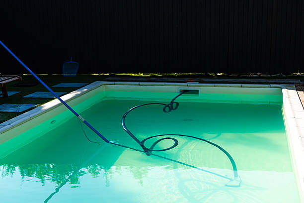 istock Cleaning a backyard swimming pool with a vacuum device 2240591429