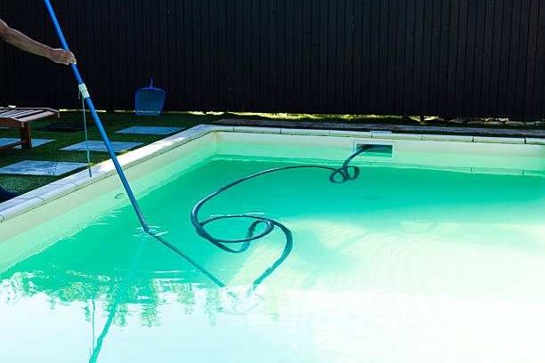 istock Human hand cleaning the pool with a vacuum hose 2240591430