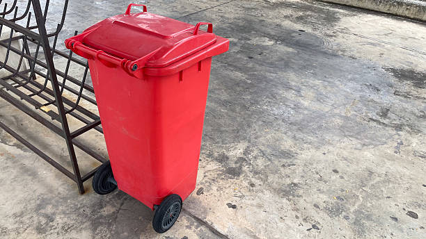 istock A red trash can placed on a concrete floor, representing waste management, cleanliness, 2240591509