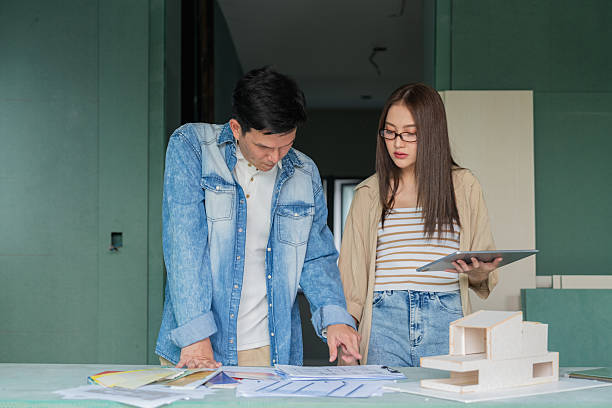 istock Asian architect designer and contractor team conducts comprehensive site survey together, inspecting construction progress and consulting on interior improvement details for residential house building project 2240596706