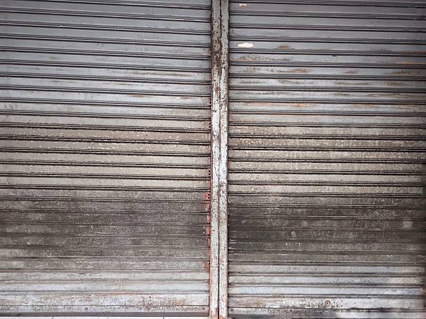 Old metal rolling shutter door. Industrial steel texture shows aging. For backgrounds, architectural design elements, and industrial or vintage themed projects