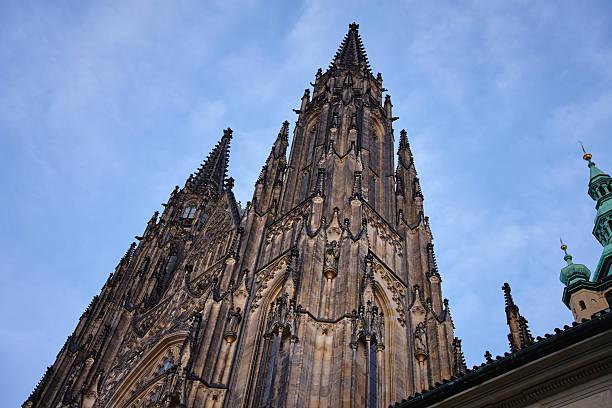View of Gothic tower of St Vitus Cathedral with clock and tall spires at Prague Castle, Czech Republic. Concept of European architecture, history and religion
