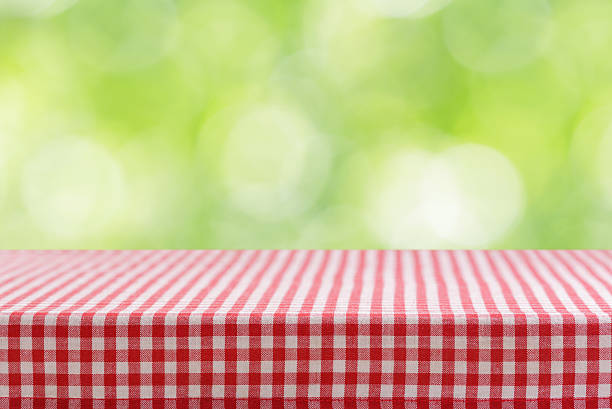 istock Empty red and white checkered tablecloth for picnic over green background 2240598976