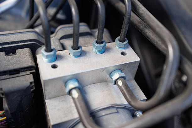 istock Car ABS module with connected hydraulic brake lines close-up view 2240600167