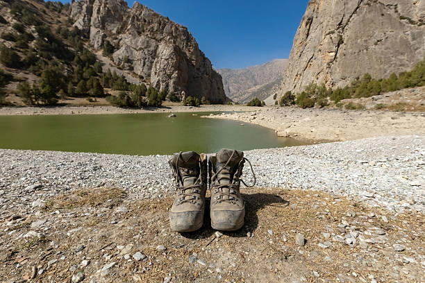 High altitude mountainous region. In the background is the triangular, pointed, majestic mountain. The focus is on the mountain. The shoes are out of focus. The mountain landscape between the model's legs.