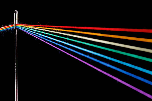 istock multi-colored threads for sewing in the form of a rainbow pass through an antique needle on a black background 2240605102