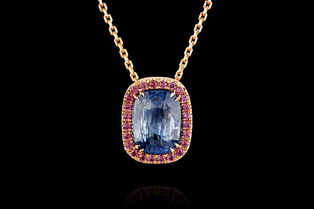 istock gold pendant with sapphire stone and diamonds on black background 2240605407