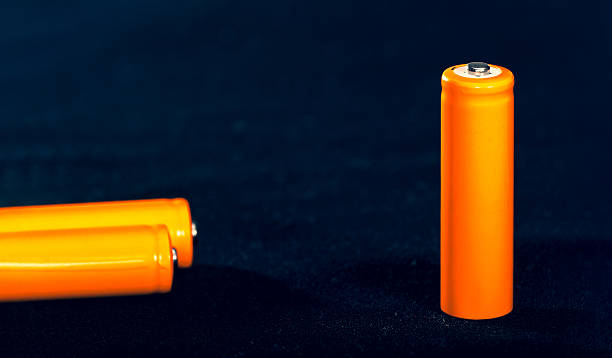 istock Three Orange AA batteries. Electricity charging. Battery for toys, electronics and equipment. Backup power supply. 2240611311