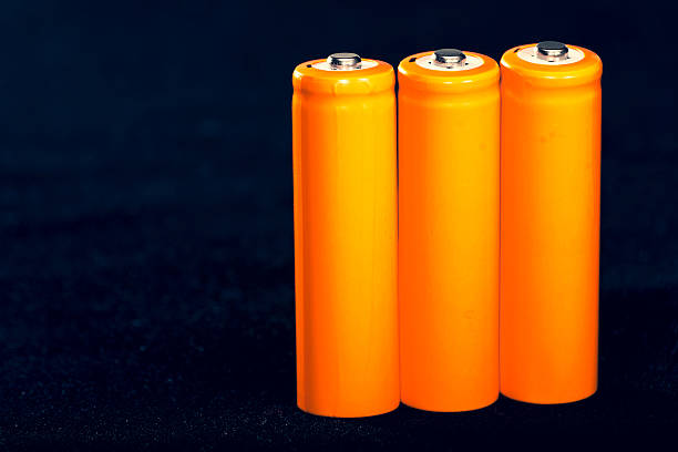 Three Orange AA batteries. Electricity charging. Battery for toys, electronics and equipment. Backup power supply.