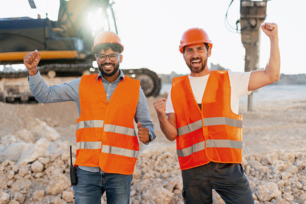 istock Happy construction workers celebrating success at worksite 2240612327