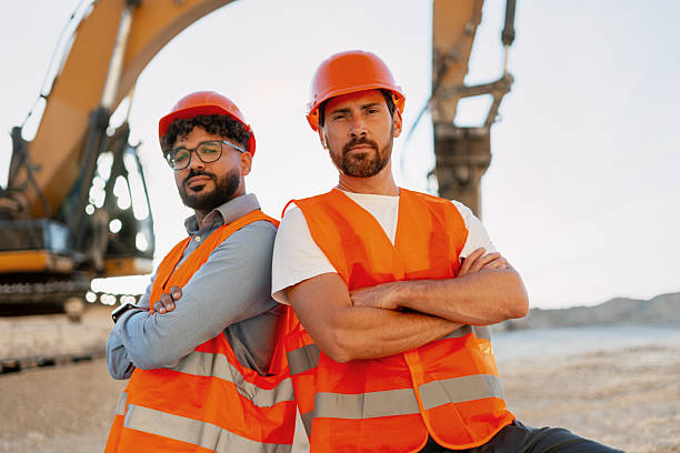 istock Confident construction engineers standing together at worksite with crossed arms 2240612330