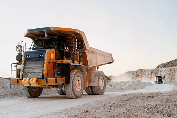 istock Mining truck covered with dust, working in an open excavation area 2240612351