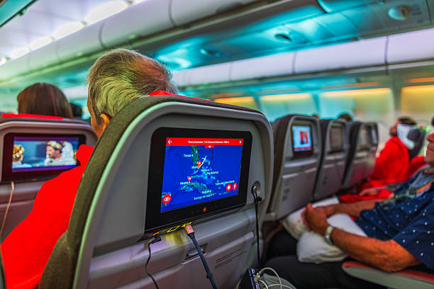 Miami . USA. April.17.2025. Airplane passengers watching seat monitors showing flight map departing from Miami.