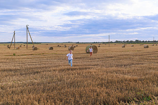 Happy family running up a grassy hill toward parents with open arms, children smiling in a joyful outdoor reunion