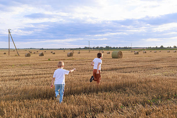 Young girls running and having fun together outdoors in the countryside at sunset