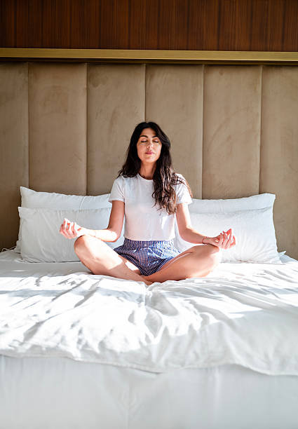 istock Young Woman practicing meditation in the bed 2240618918