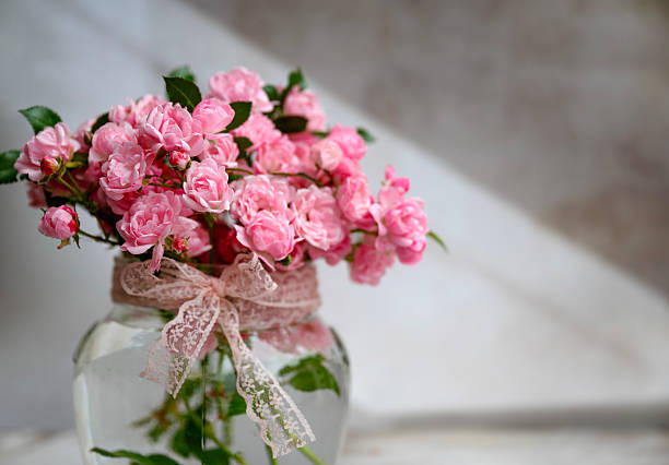 Pink Roses in glass  vase on shadows background