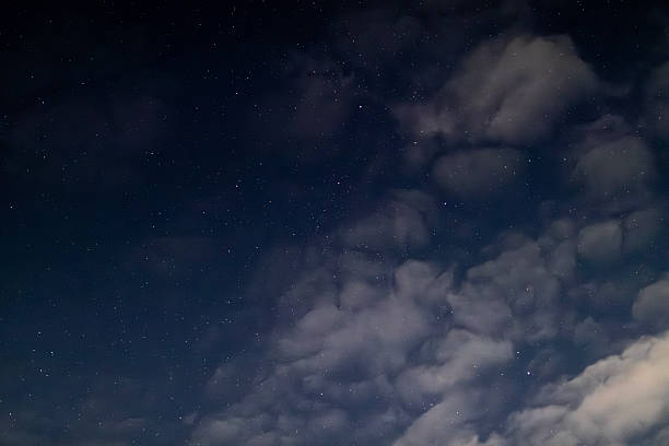 istock A dramatic night sky with bright stars peeking through patches of thick clouds. A concept of mystery, dreams, and the vastness of the universe. 2240620751