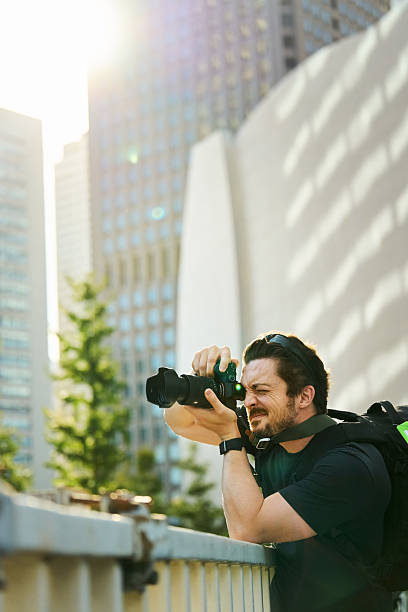 istock Male tourist photographing cityscape using camera during vacation 2240622449