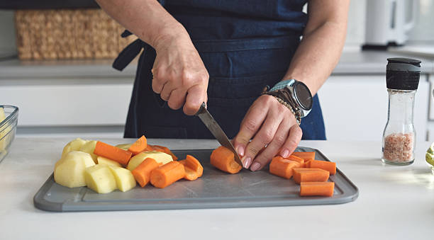 istock Woman Is Cutting Raw Carrot 2240622926