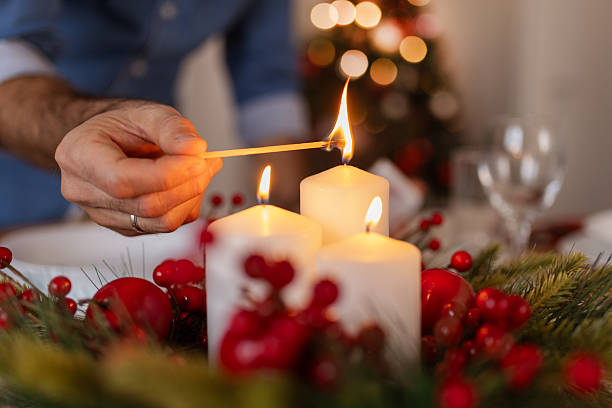 istock Man Lighting Candles on Festive Christmas Table with Red Berries & Pine 2240626214