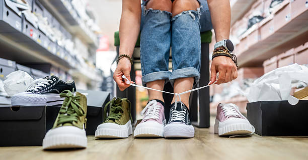 istock Woman Trying On Sneakers In Different Colors 2240626498