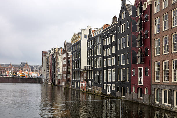 Amsterdam, Netherlands - April 21, 2023: Typical gabled houses on Damrak district in  Amsterdam, Netherlands
