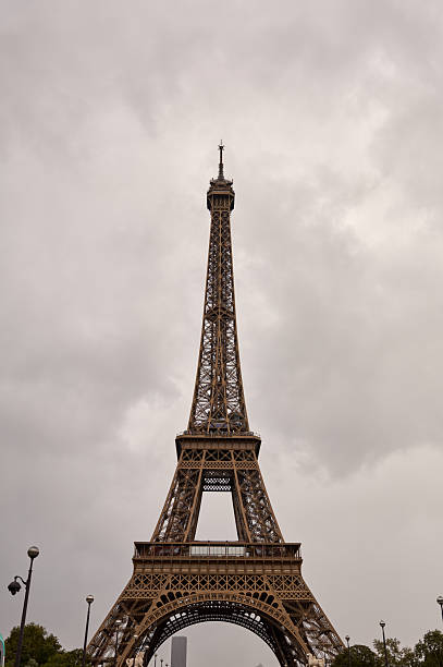 Eiffel tower, an iconic landmark, standing against a heavily clouded sky