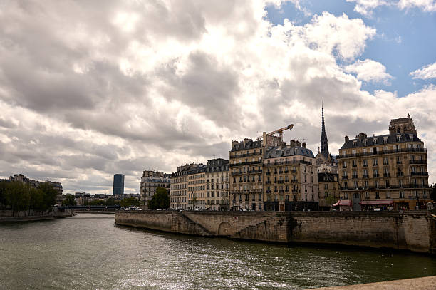 Buildings lining the seine river under a cloudy sky in paris, france