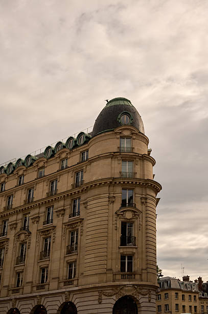 Classic haussmannian architecture featuring a corner dome and overcast sky