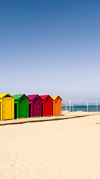 istock Colorful Beach Huts On Sandy Shoreline 2240634059