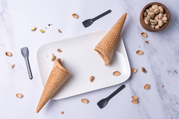 istock Top view of two ice cream cones and some pistachio kernels. 2240636180