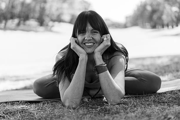 istock Woman smiling while resting in a comfortable yoga pose on the ground 2240644956