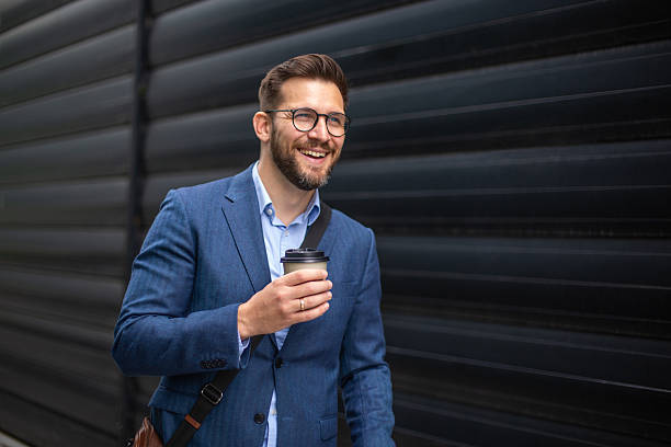 istock Smiling businessman enjoying coffee on urban commute 2240645751
