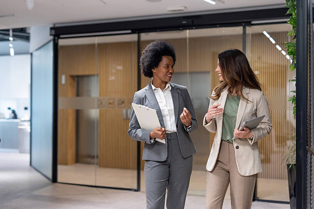 istock Businesswomen walking and talking in modern office 2240650087