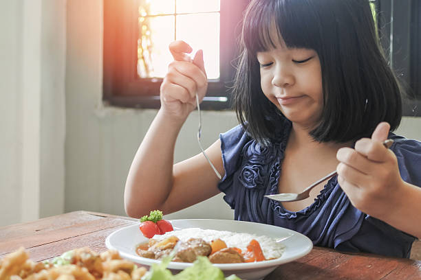 istock Asian kid, school girl child, picky eater with Anorexia, Bulimia Nervosa; eating problem, avoidant restrictive food intake disorder (ARFID), losing appetite with disliked healthy food meal 2240650122