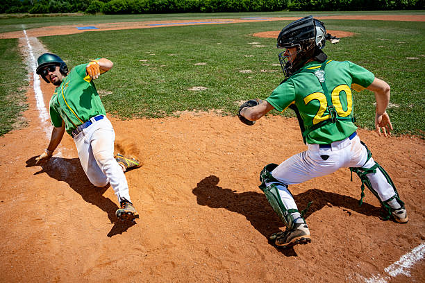 istock Baseball Player Slides into Home Plate, Catcher Ready to Tag 2240650210