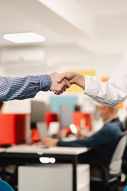 istock Business professionals engaging in a handshake in a modern office setting during a collaborative meeting 2240650509